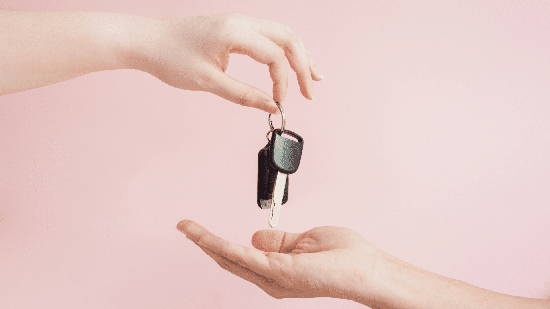 Hand giving car keys to another hand